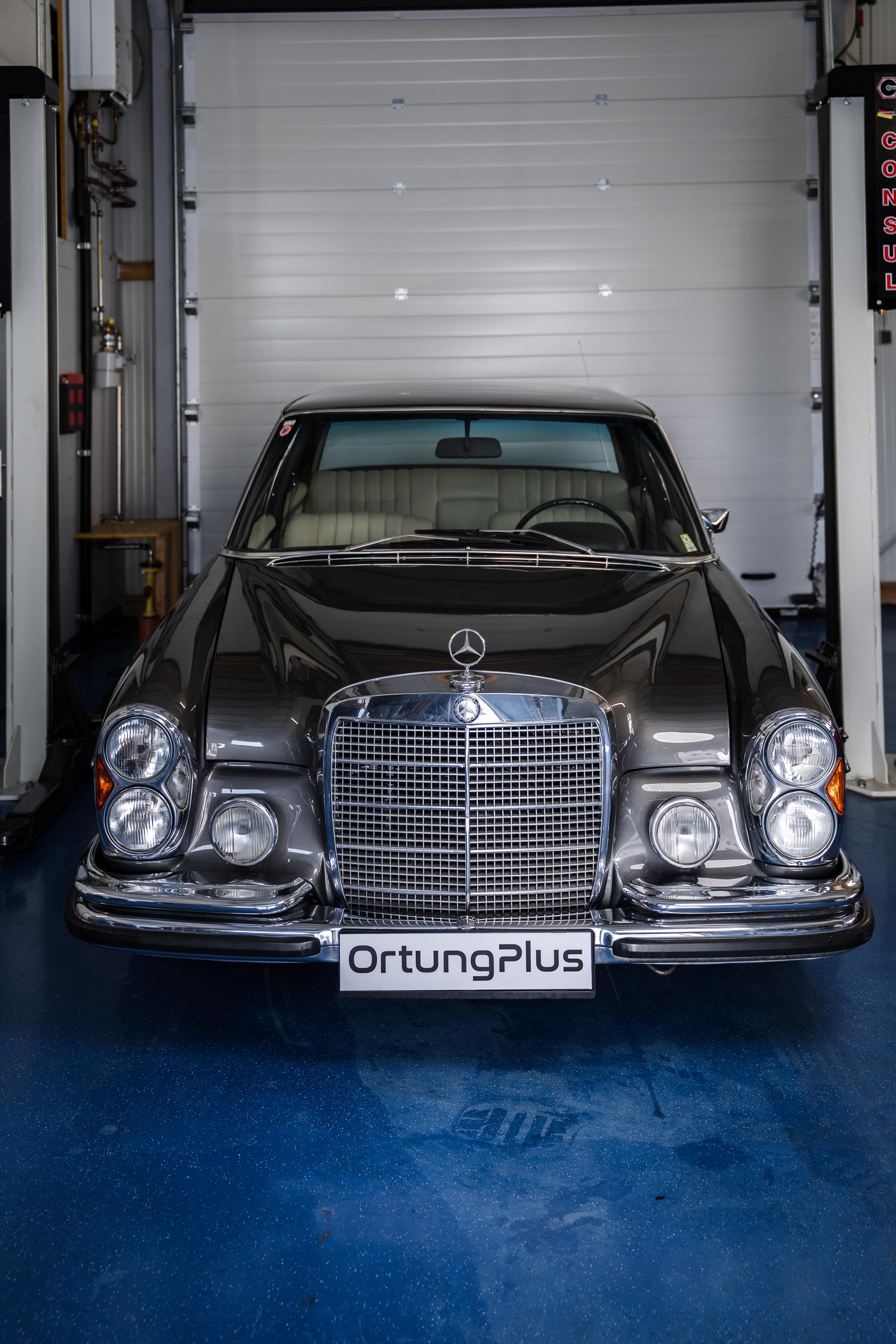 Klassischer Mercedes mit Ortungplus-Kennzeichen in einer Fachwerkstatt